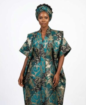 Woman wearing a structural emerald green and gold metallic brocade African kaftan dress with matching headwrap.
