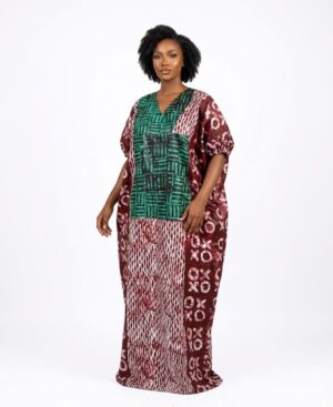 Woman wearing a long burgundy and green African batik print Bubu kaftan dress with puffed sleeves.