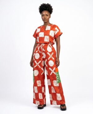 Woman wearing a terracotta and white African Batik two-piece set with wide-leg pants and cargo pockets.