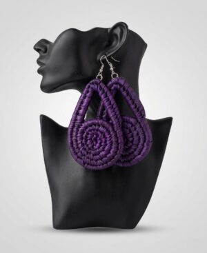 Pair of large handmade woven statement earrings in deep purple displayed on a black female mannequin bust against a gray studio background.
