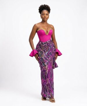 Woman wearing a magenta strapless corset top with a beaded gold neckline and a long purple African print draped skirt.