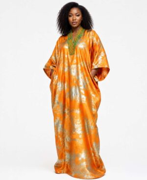 Woman wearing a floor-length metallic orange and silver African kaftan dress with green beaded necklace.
