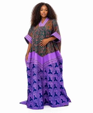 Full-length view of a woman wearing a purple and green mixed-print African Ankara kaftan dress with a chevron waist and V-neckline.