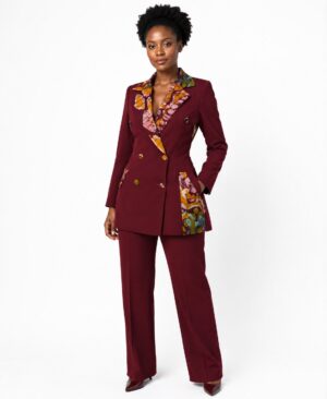 Professional woman wearing a burgundy double-breasted suit with African Ankara print on the lapels and pockets.