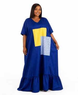 Woman wearing a royal blue oversized kaftan dress with yellow and pinstripe geometric patches and a ruffled hem.