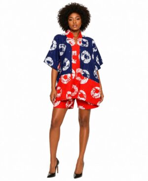 Woman wearing a navy and red African print kimono jacket and matching shorts set with black heels.