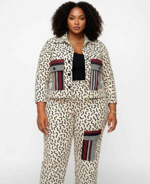 Full-length view of a woman wearing a cream and black abstract African print two-piece set with a utility jacket and matching pants.